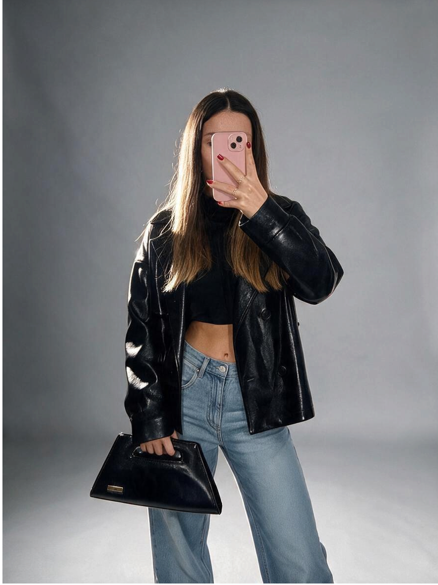 Modella con borsa Amatì Star nera in ecopelle naplak effetto vernice con manico intagliato e placchetta dorata