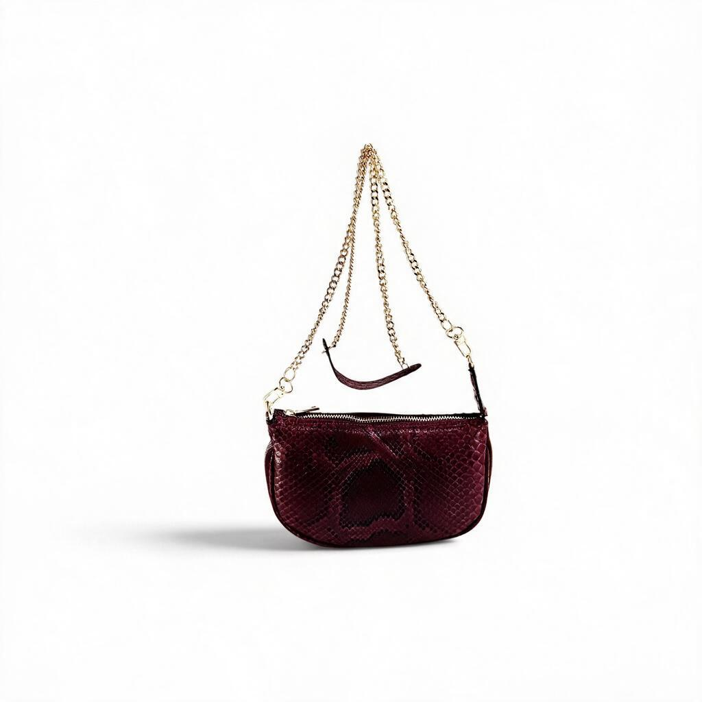 Borsa Amatì Perla in vero pitone bordeaux con tracolla a catena oro removibile e chiusura zip dorata.