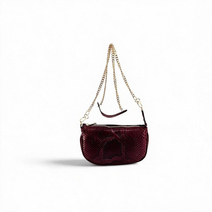 Borsa Amatì Perla in vero pitone bordeaux con tracolla a catena oro removibile e chiusura zip dorata.