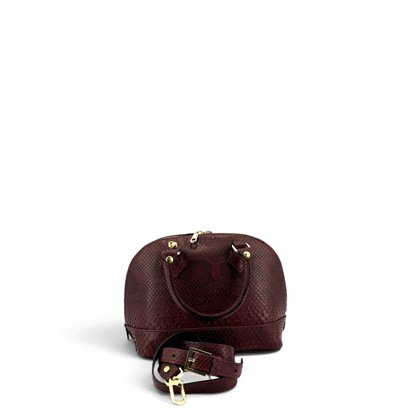 Borsa a cupola Amatì Rubina in vero pitone bordeaux con dettagli dorati, manici e tracolla regolabile removibile.