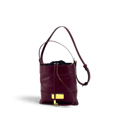 Borsa a secchiello Amatì bordeaux con chiusura a coulisse, placca metallica dorata e tracolla regolabile