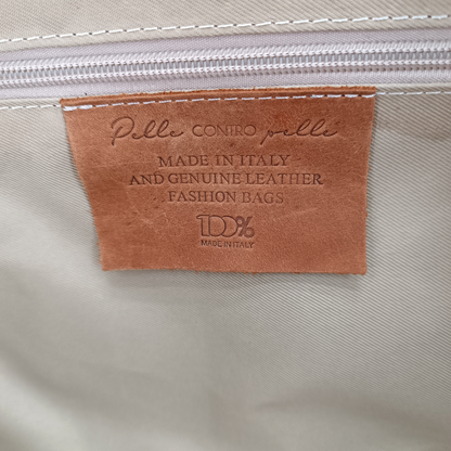 Etichetta interna in pelle del borsone Amatì Apollo con scritta Made in Italy e 100% vera pelle su fodera chiara